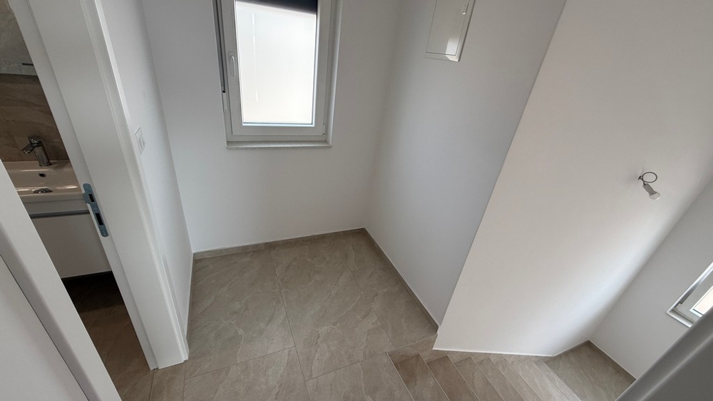 Prostor schodiště s oknem a přístupem do koupelny