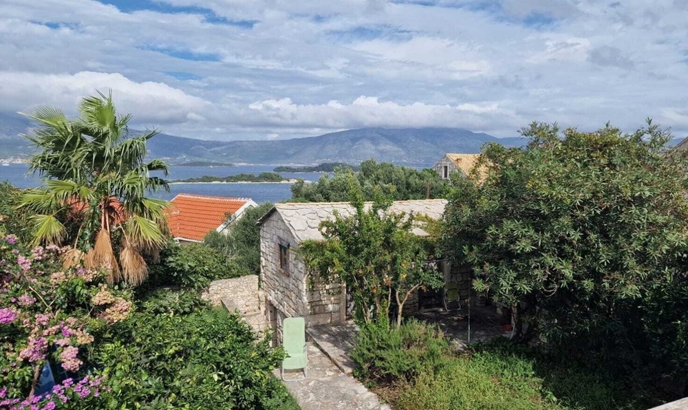 Výhled na moře a zahrada s domem z přírodního kamene