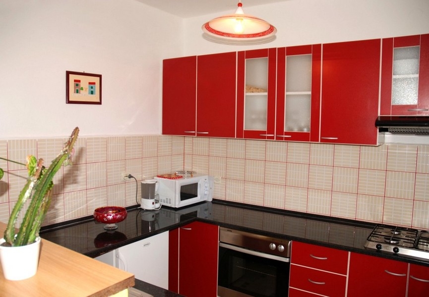 Kuchyně s červenými vestavěnými skříněmi