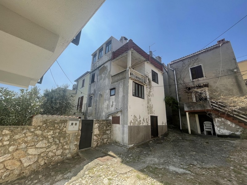 Vnější pohled na městský dům, který potřebuje rekonstrukci