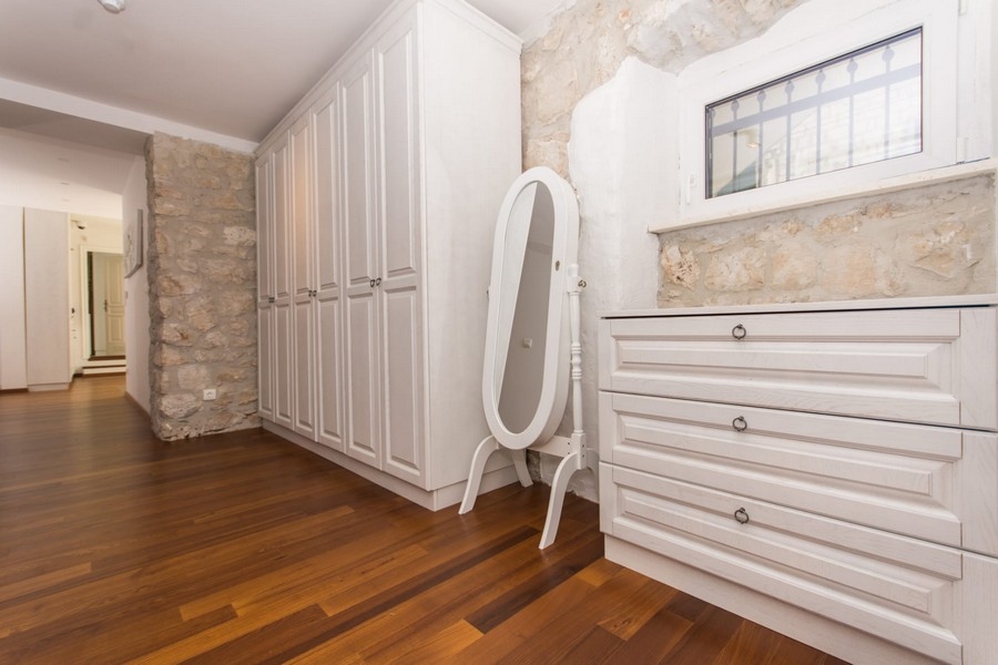 Šatna s vestavěnými skříněmi a zrcadlem