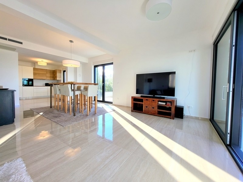 Světlý obývací pokoj s TV a vstupem na terasu