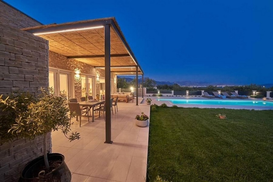 Krytá terasa se zahradou a bazénem v noci