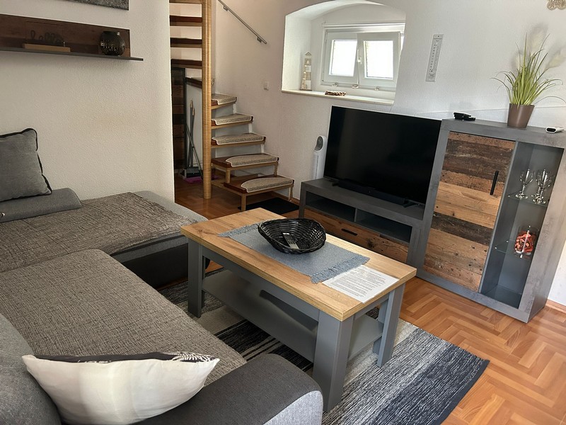 Obývací část s televizí a schodištěm