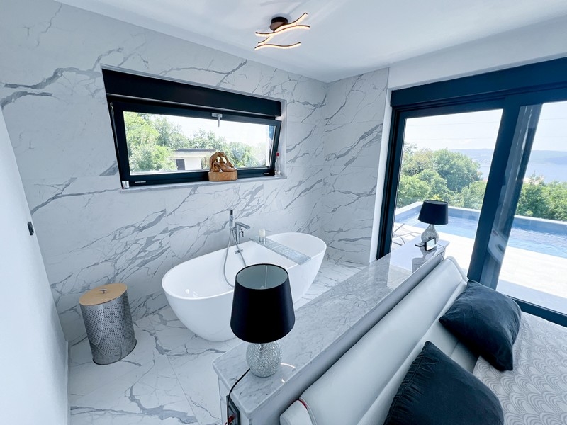 Koupelna s volně stojící vanou a výhledem na moře
