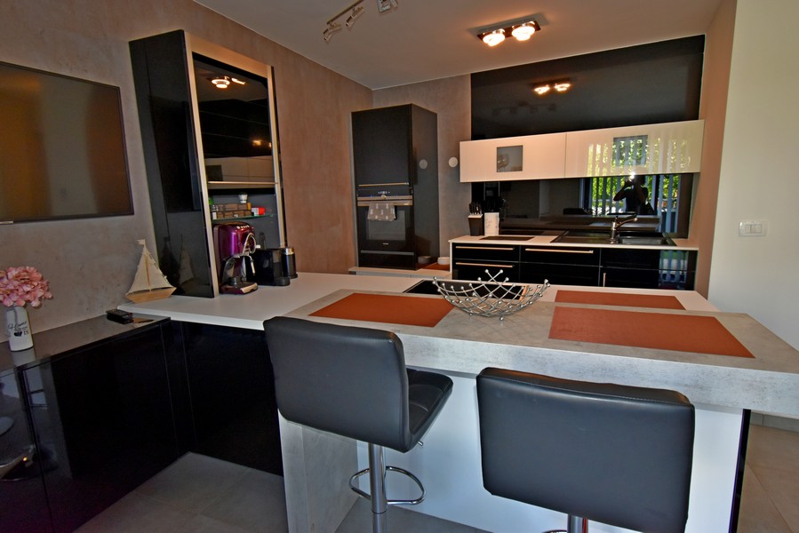 Moderní kuchyně s ostrůvkem a barovými židlemi