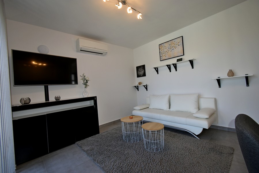 Obývací pokoj s pohovkou, TV a klimatizací