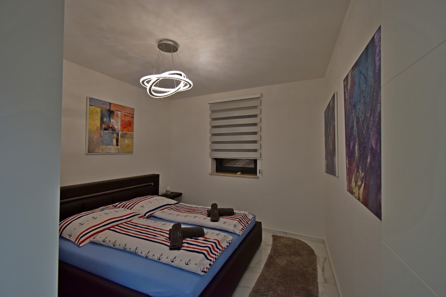 Ložnice s manželskou postelí a nástěnnými malbami