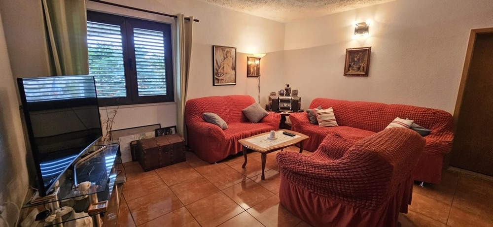 Obývací pokoj se sedací soupravou a televizí