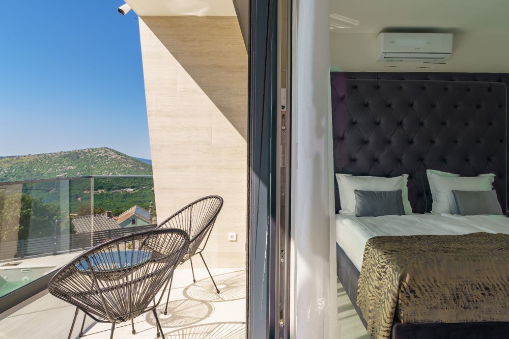 Manželská postel ve světlé ložnici