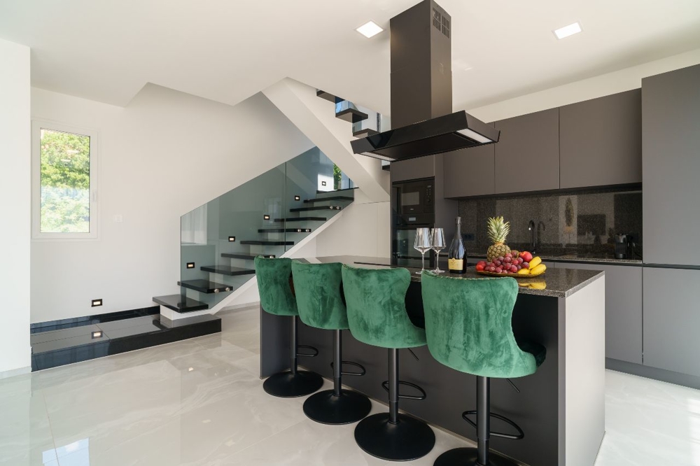 Moderní kuchyně s ostrůvkem a barovými židlemi