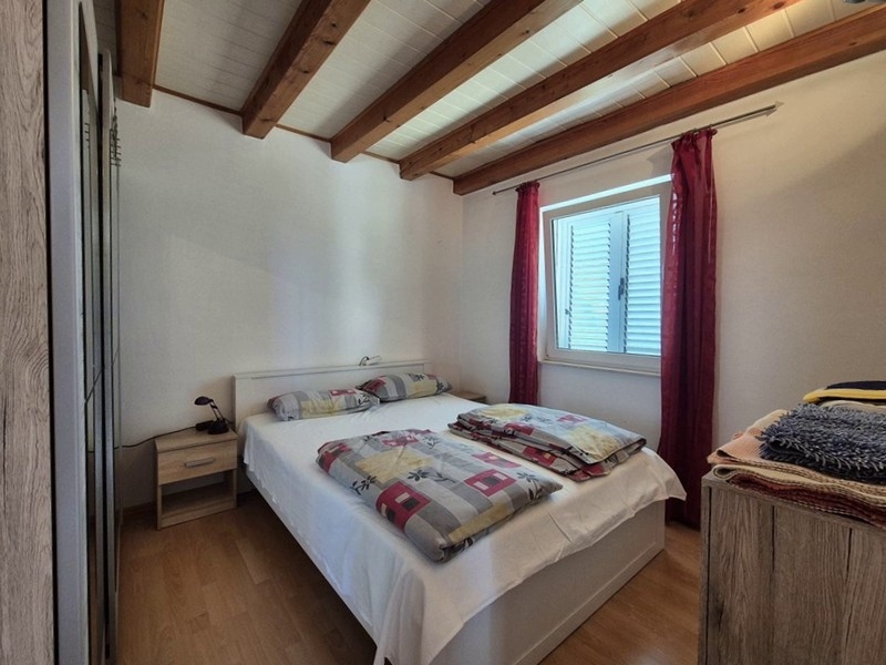 Ložnice s manželskou postelí a trámovým stropem