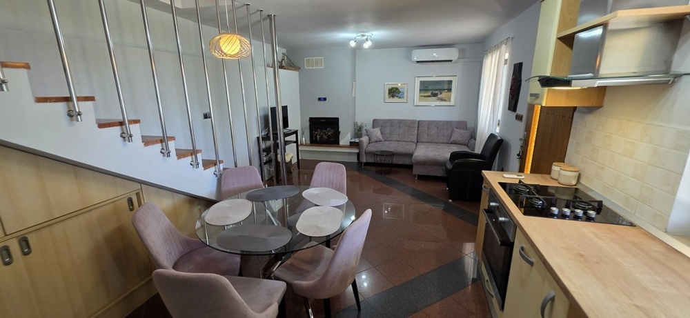 Moderní obývací a jídelní kout se schodištěm