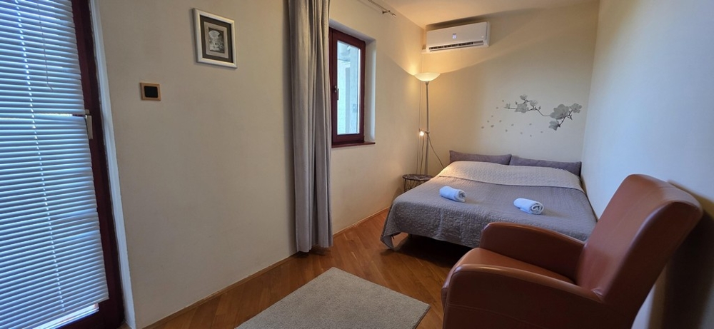 Malá ložnice s manželskou postelí a křeslem