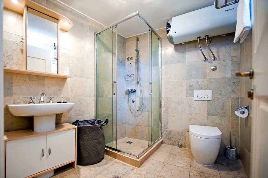 Koupelna se sprchovým koutem a dlážděnou podlahou