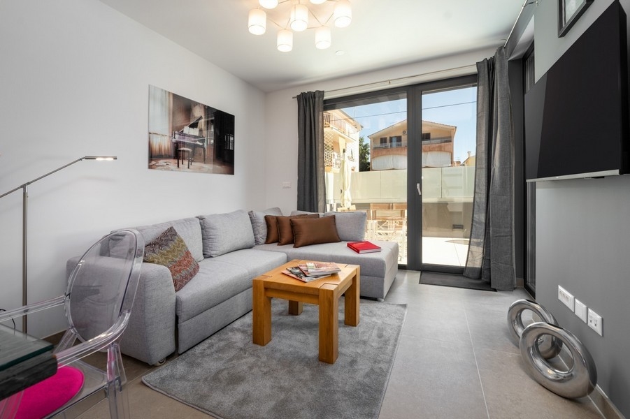 Obývací pokoj s rohovou pohovkou a vstupem na terasu