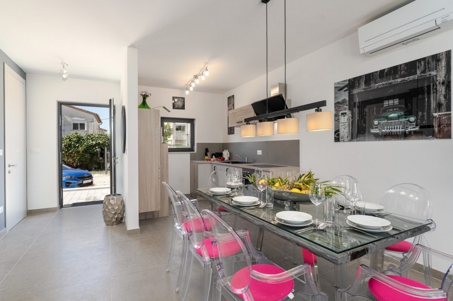 Jídelní kout se skleněným jídelním stolem a moderní kuchyní