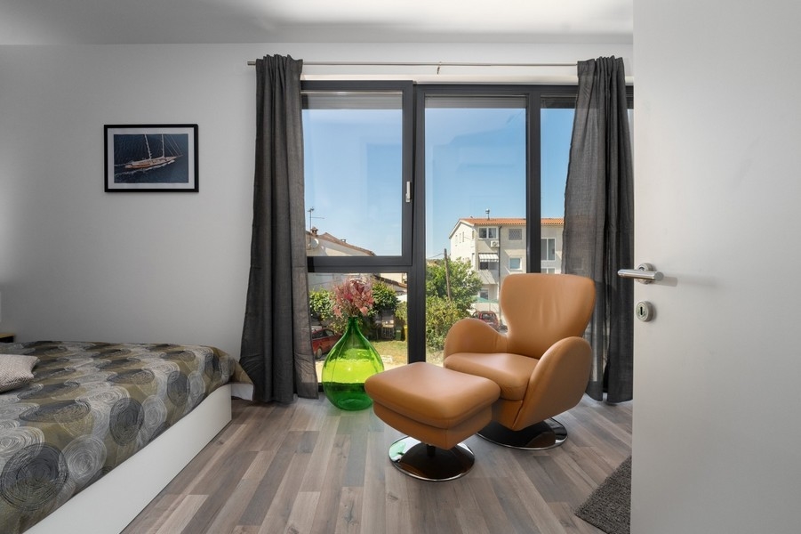 Ložnice s křeslem a velkým oknem