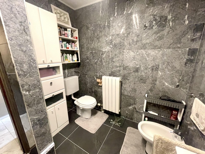 Koupelna s WC, bidetem a šedými obklady