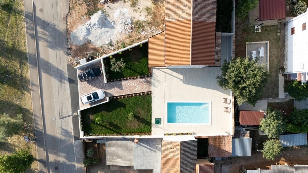 Letecký pohled na nemovitost s bazénem a parkovacími místy