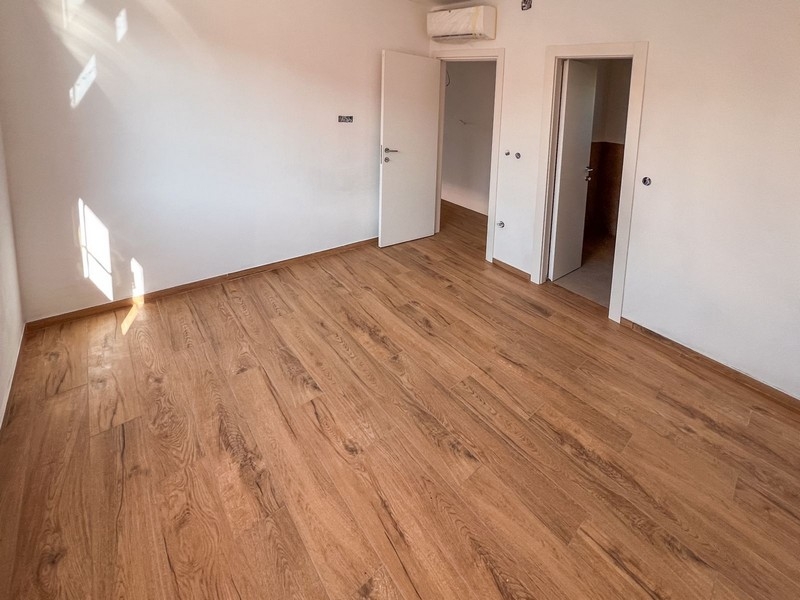 Světlá ložnice s dřevěnými podlahami