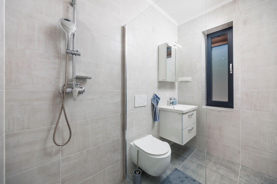 Moderní koupelna se sprchovým koutem a oknem