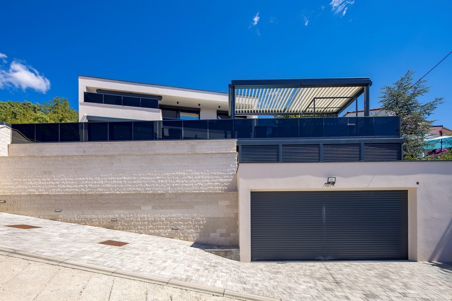 Pohled z ulice na moderní vilu s garáží