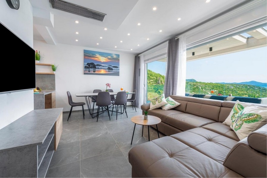 Světlý obývací pokoj s velkými okny a panoramatickým výhledem