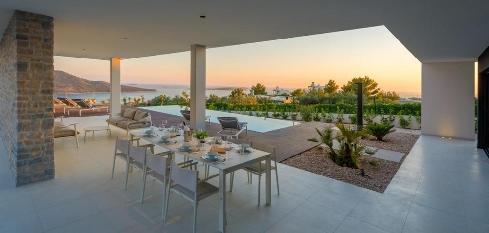 Krytá terasa s jídelním stolem a výhledem na moře