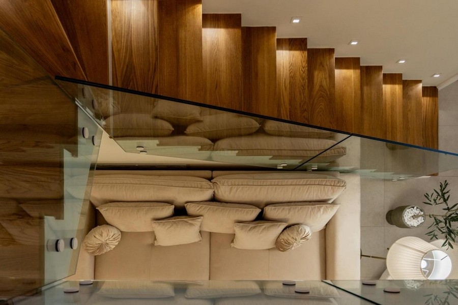 Pohled na schodiště s dřevěnými schody a skleněným zábradlím