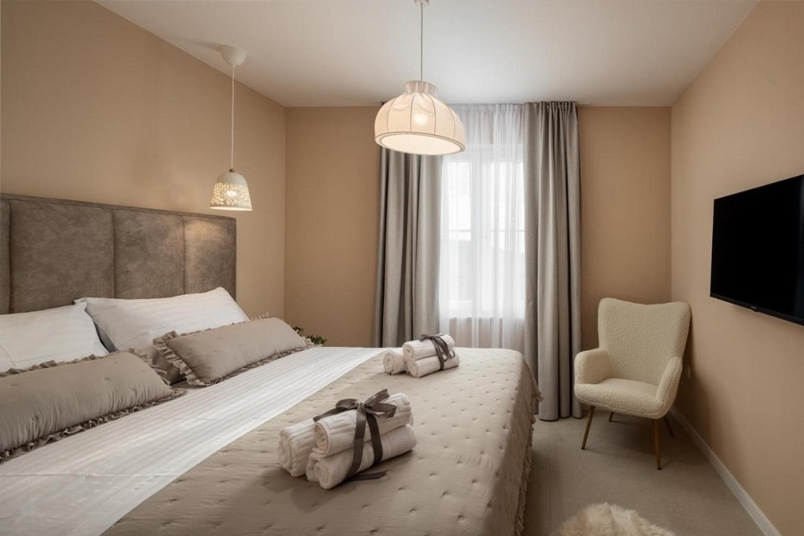 Ložnice s manželskou postelí, TV a křeslem