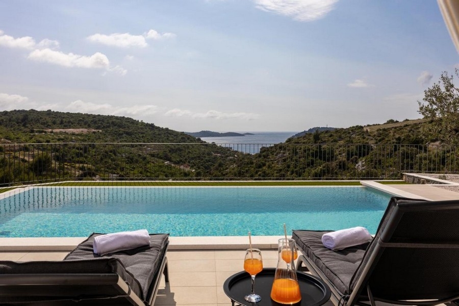 Nekonečný bazén s výhledem na moře a lehátky