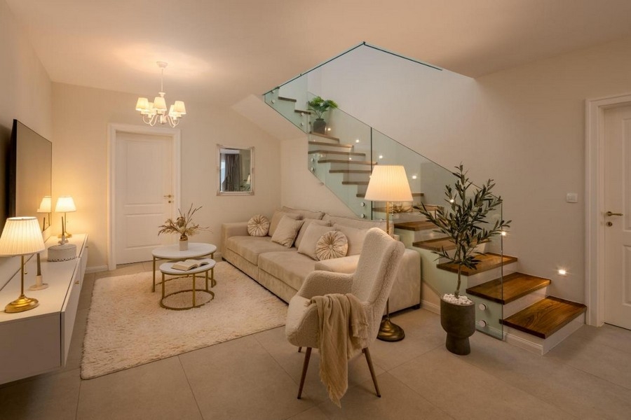 Obývací pokoj s pohovkou a moderním schodištěm