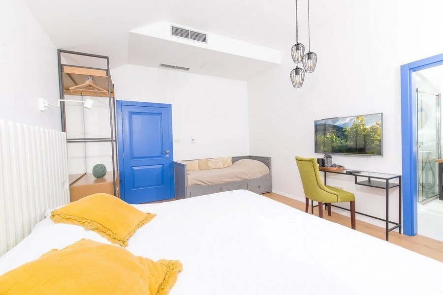 Ložnice s manželskou postelí, psacím stolem a televizí