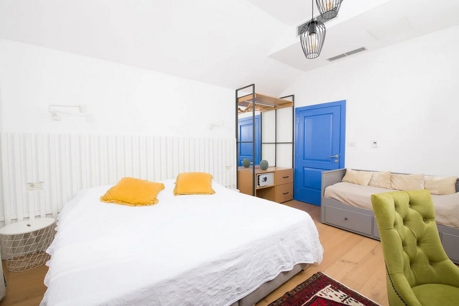 Ložnice s manželskou postelí, modrými dveřmi a šatní skříní