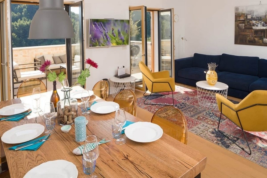 Jídelna s velkým dřevěným stolem a obývacím prostorem