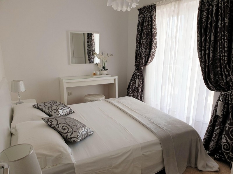 Ložnice s manželskou postelí a oknem od podlahy ke stropu