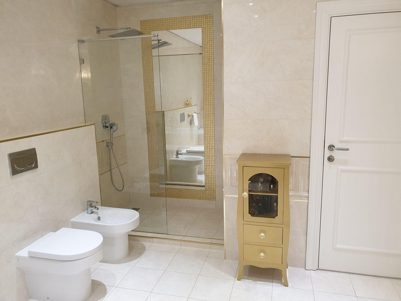 Koupelna se sprchovým koutem, bidetem a světlou dlažbou