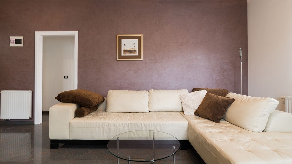 Obývací pokoj se světlou koženou pohovkou a skleněným stolem