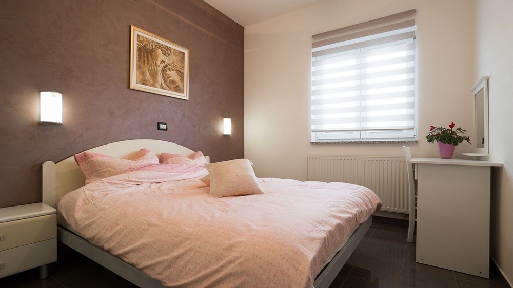 Ložnice s manželskou postelí a teplým designem