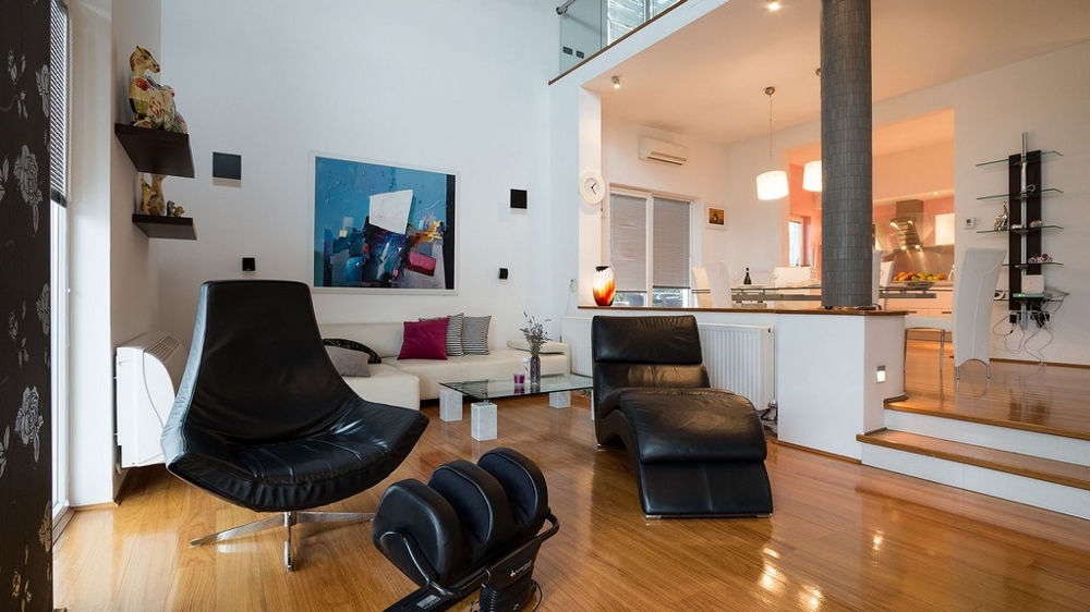 Obývací pokoj s koženými křesly a otevřenou kuchyní