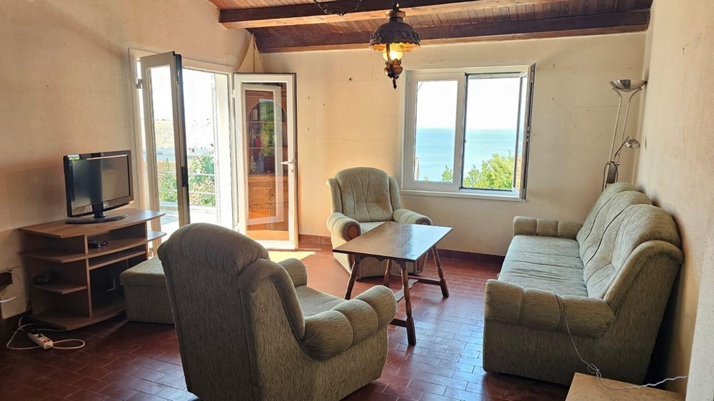 Obývací pokoj se vstupem na terasu a výhledem na moře