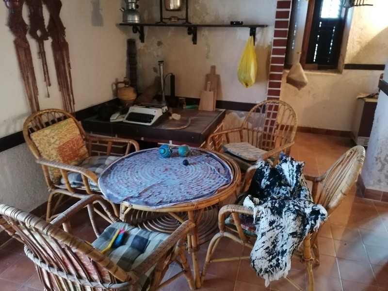 Posezení s ratanovým nábytkem a malou kuchyňkou