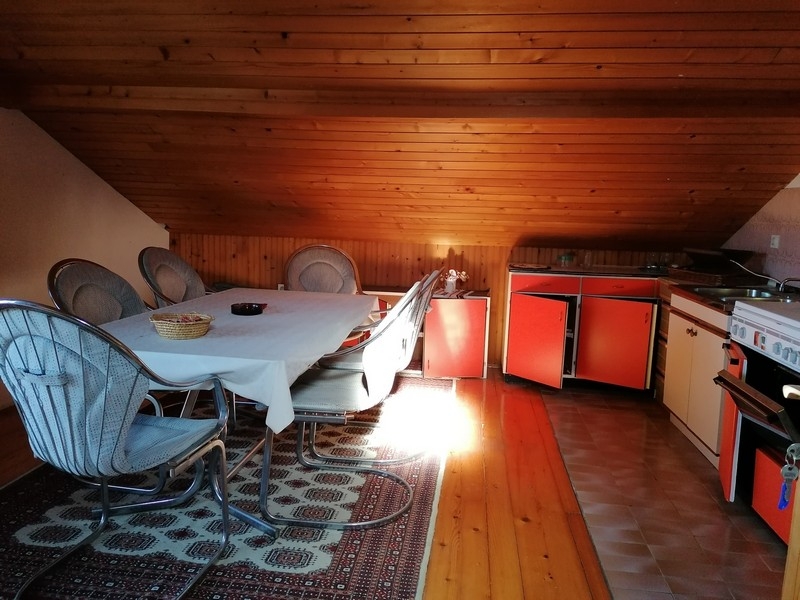 Podkrovní kuchyně s jídelním koutem a šikmou střechou