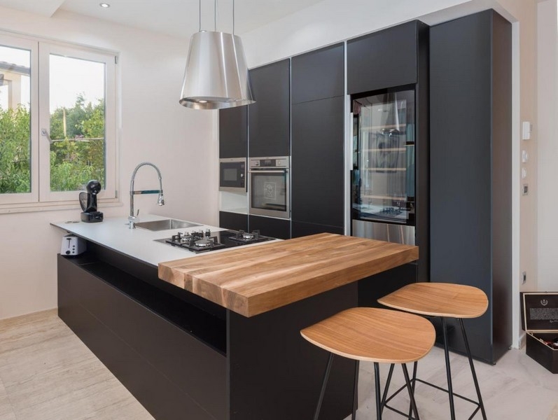 Moderní černá kuchyně s ostrůvkem a dřevěným pultem