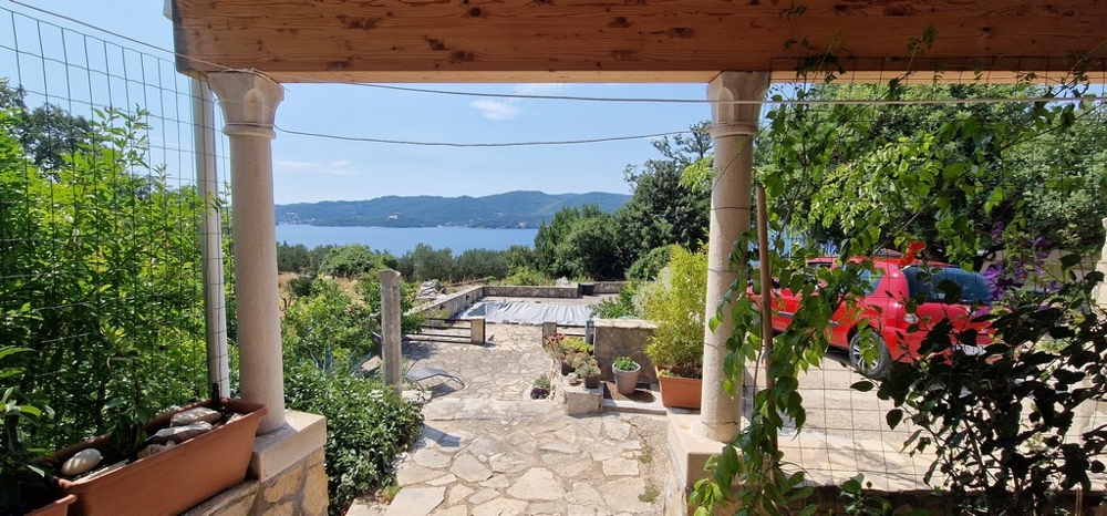 Krytá terasa s výhledem na krytý bazén a moře.