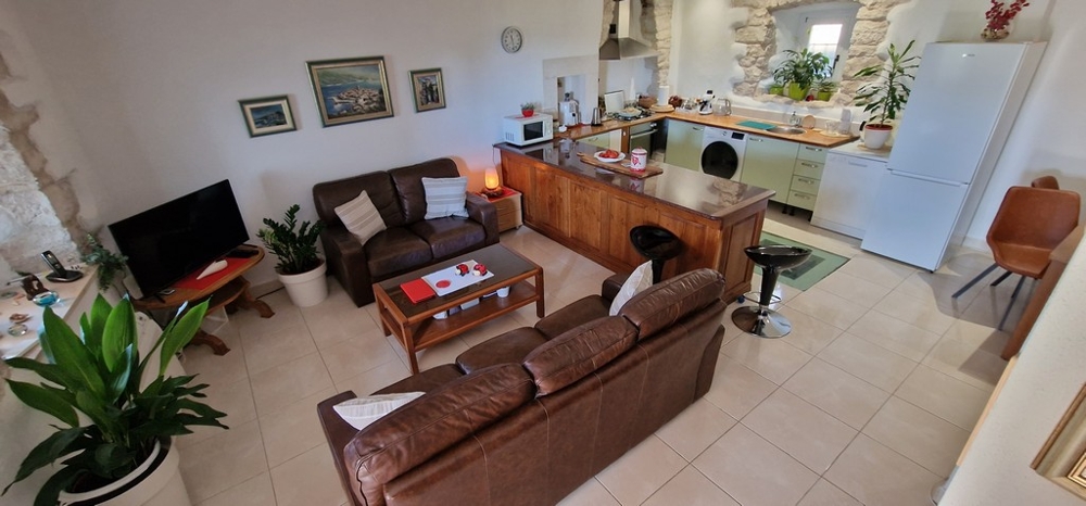 Obývací pokoj s pohovkou a kuchyňským koutem