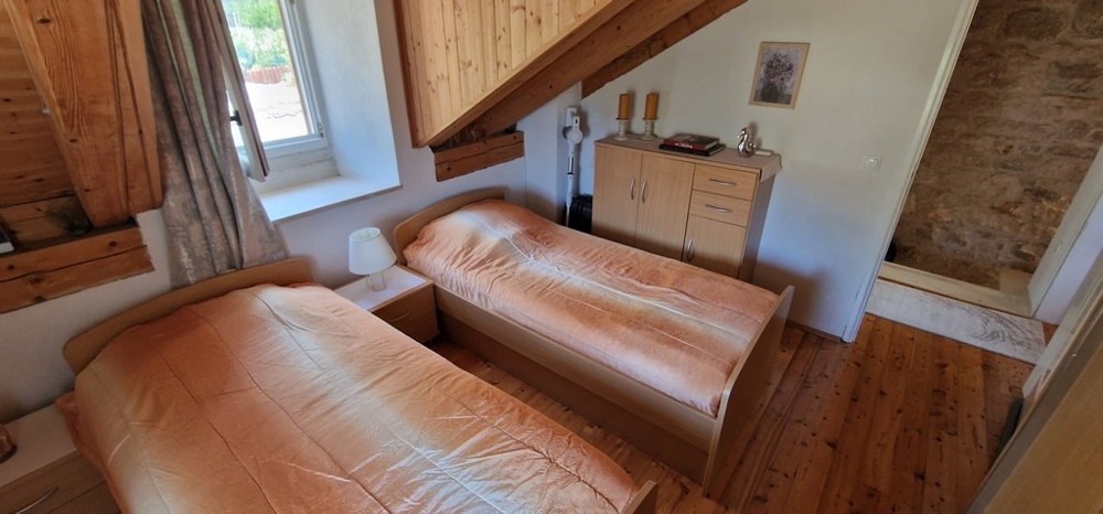 Ložnice se dvěma samostatnými lůžky a dřevěnou podlahou