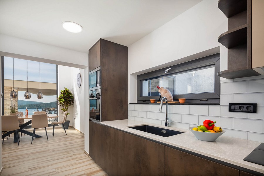 Moderní kuchyně s jídelním koutem a výhledem na moře