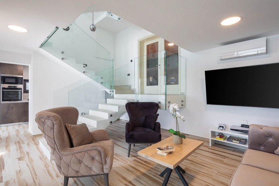 Obývací pokoj se schodištěm a skleněným zábradlím